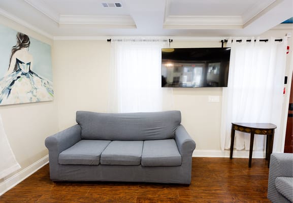 Common area with a couch and TV in a bright setting