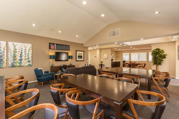 A spacious common area with dining tables and lounge seating.