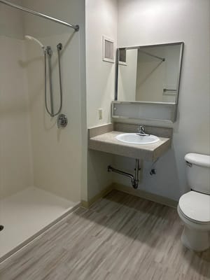 A clean bathroom with a shower, sink, and toilet.