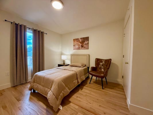 Cozy private room with a bed and armchair