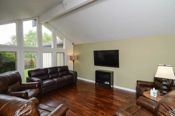 A cozy lounge with leather sofas and a wall-mounted TV.