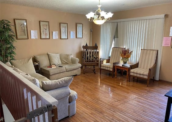 A cozy living room with seating arrangements and decorative elements.