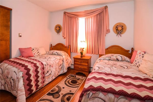A cozy shared bedroom with two twin beds and decorative curtains