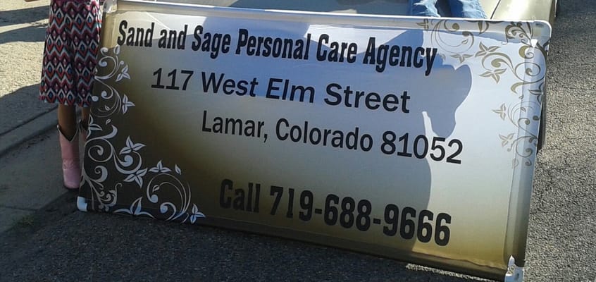 Sign displaying the name and address of Sand and Sage Personal Care Agency.