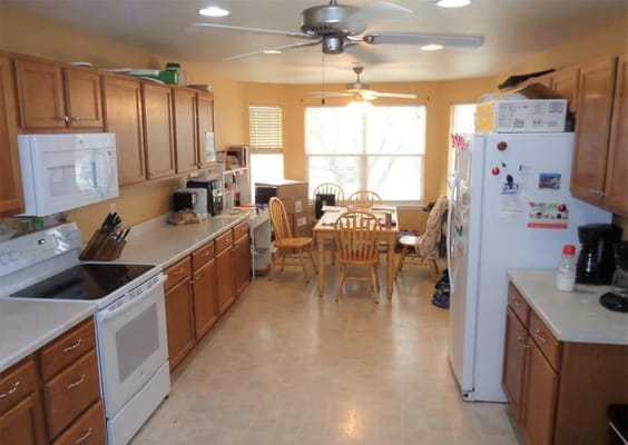 Light-filled kitchen with wooden cabinets and dining area.