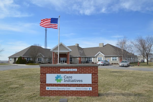 Exterior view of Avoca Lodge Assisted Living with American flag