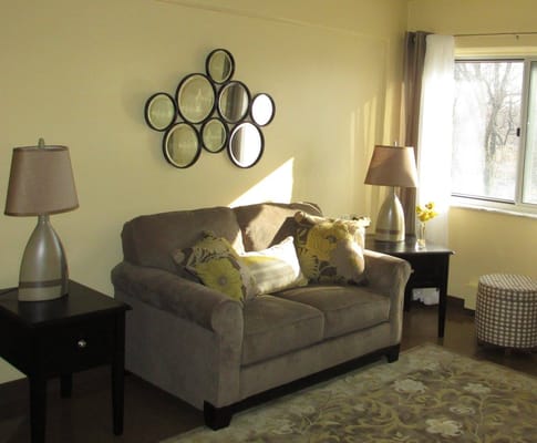 Cozy living room with a sofa, lamps, and decorative mirrors