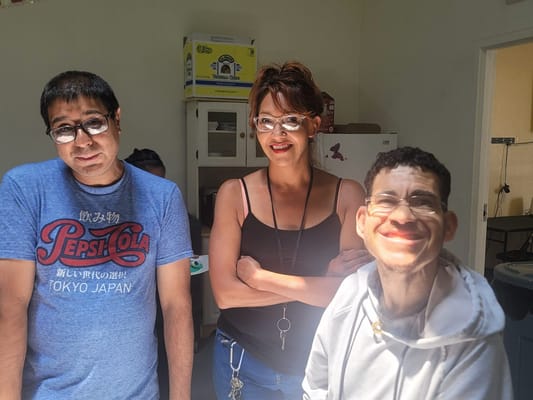 Three staff members smiling in an activity room