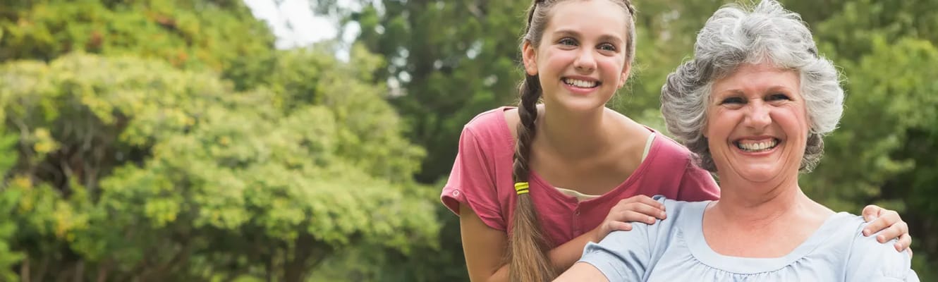 A smiling resident outdoors with a visitor