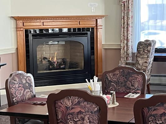 Dining area with a cozy fireplace and floral decor