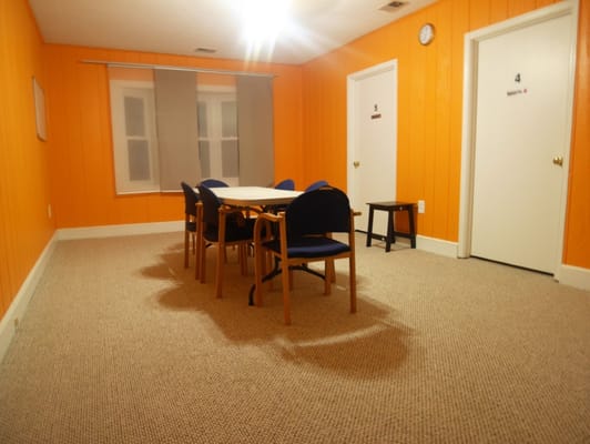 A common area with a table and chairs in an orange room
