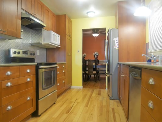 Bright kitchen space with wooden cabinets and a dining area visible