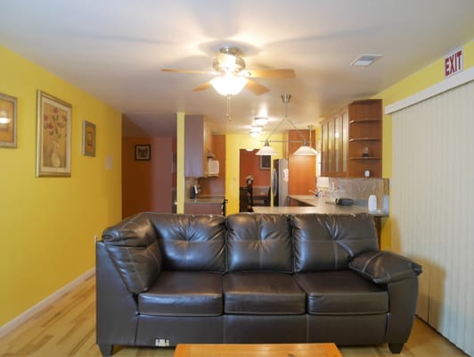 Cozy interior living area with brown couch and kitchen in view