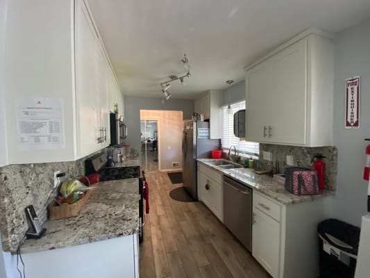 A kitchen area with granite countertops and appliances