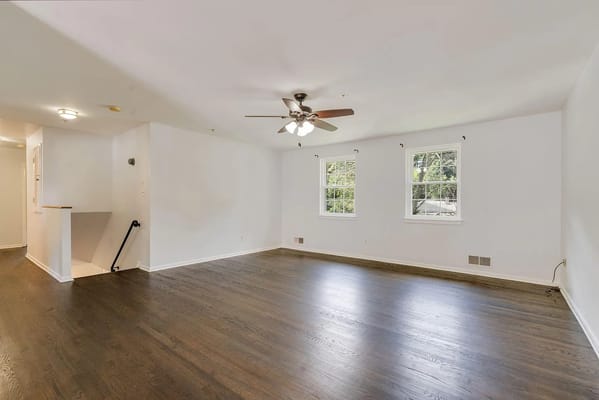 Bright and spacious living room with hardwood floors and windows