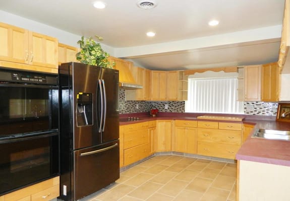 A spacious kitchen with wooden cabinets and modern appliances
