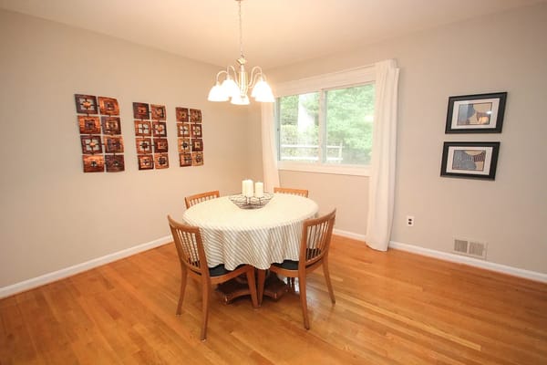 Cozy dining room with a round table and artwork on the walls.