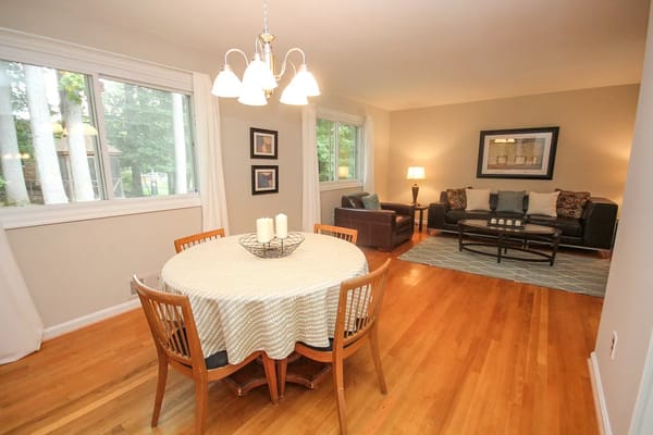 Bright dining table with chairs and a cozy living room setup.