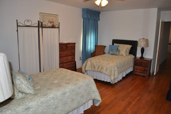 A cozy resident room with two beds and warm decor