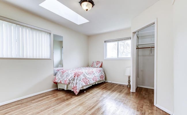 Bright and spacious bedroom with a bed and closet.