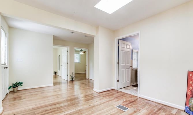 Bright and spacious entryway with hardwood floors and open doors