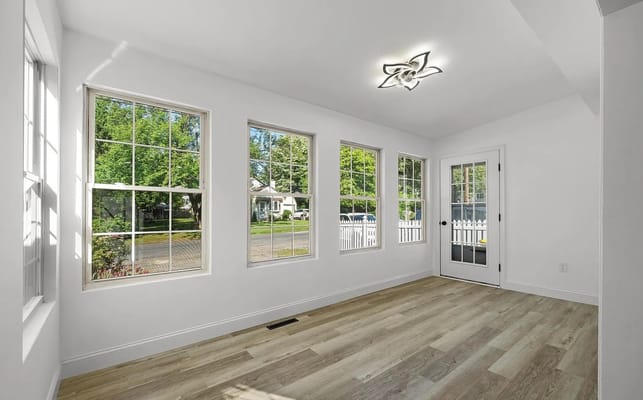 Sunroom with large windows and wooden flooring at Marivic House I.