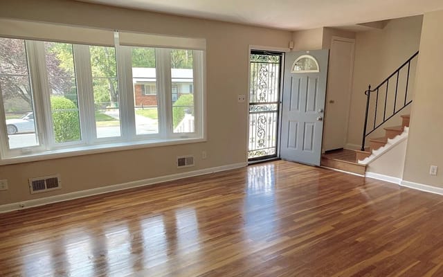 Spacious living room with hardwood floors and large windows