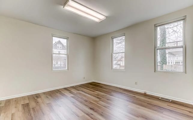Bright interior room with windows and hardwood flooring