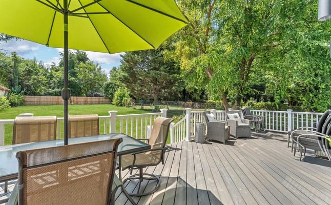 Deck with seating and green umbrella at Desky Assisted Living