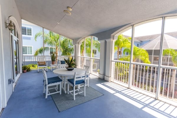 Patio area with table and chairs surrounded by plants