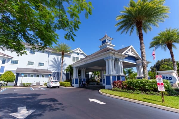 Main entrance of Alto Stuart with palm trees and blue sky