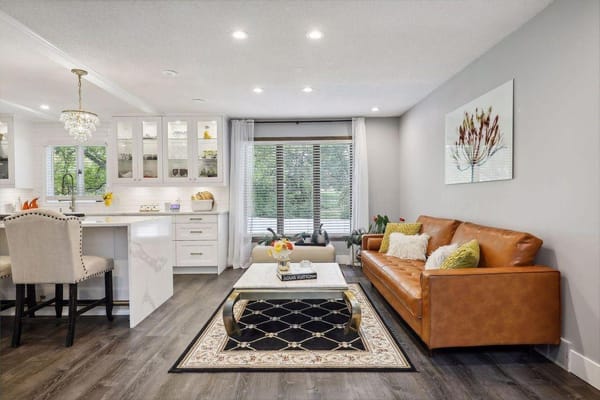 A warmly lit living room featuring a leather couch and a stylish coffee table.