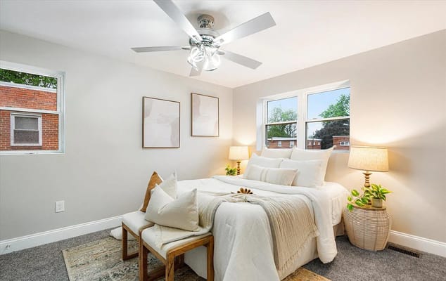 Bright and cozy bedroom with a bed, two lamps, and windows