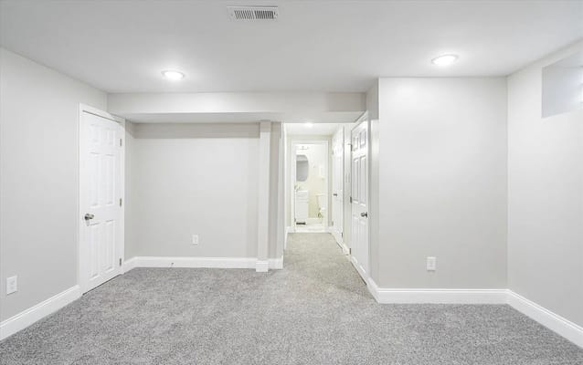 Spacious common area with soft carpet and bright lighting