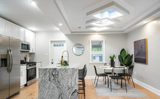 Contemporary kitchen with dining area showcasing a marble island and modern decor
