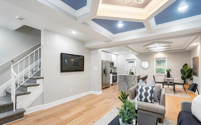 Modern living room with a staircase and kitchen area