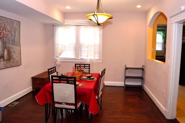 Dining area with a red table set and art on the wall