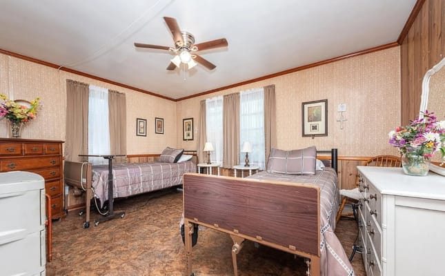 A cozy bedroom with two beds and decorative elements in Clem And Doll Assisted Living.