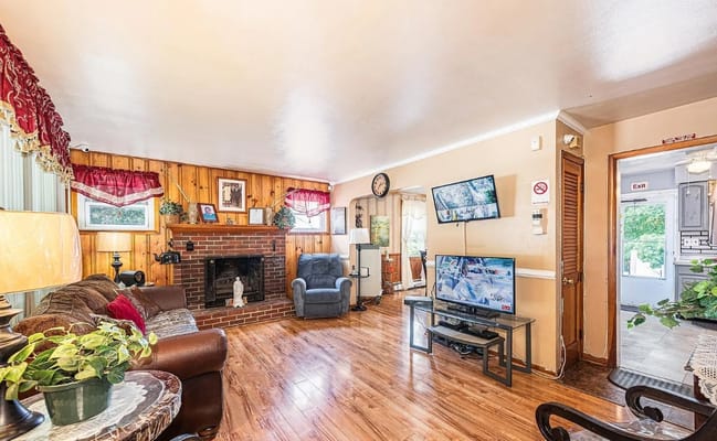 Living room with a fireplace, TV, and seating area