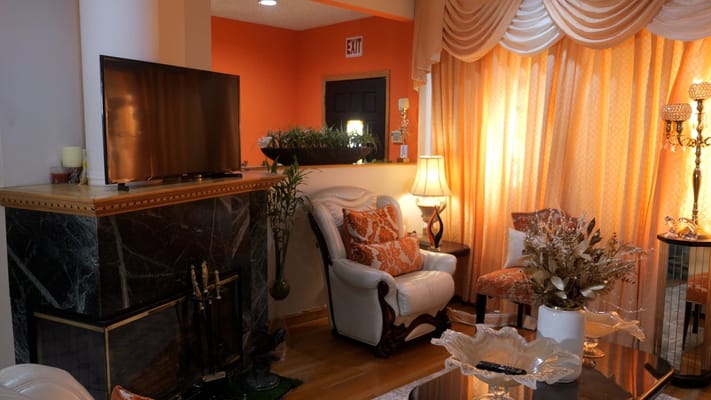 Comfortable living room with a TV, decorative curtains, and plants