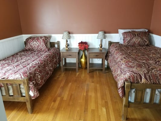 A cozy bedroom with two twin beds, nightstands, and decorative elements.