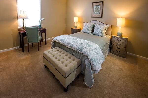 A well-furnished bedroom with a bed, nightstands, and a writing desk.