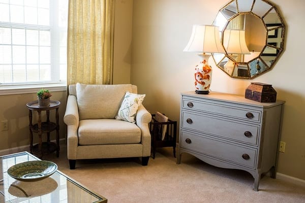 Cozy living room with a chair, dresser, and decorative lamp