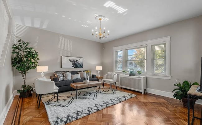 Comfortable living room with sofa, chairs, and natural light.