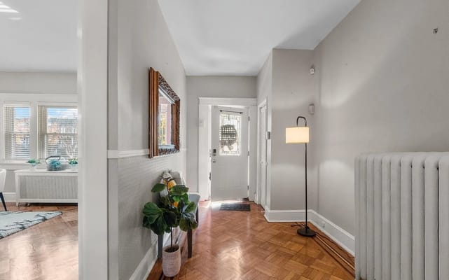 Bright entryway with a floor lamp and decorative mirror