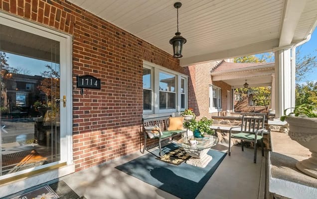 Porch area with seating and greenery outside Taylor Made Assisted Living Center II