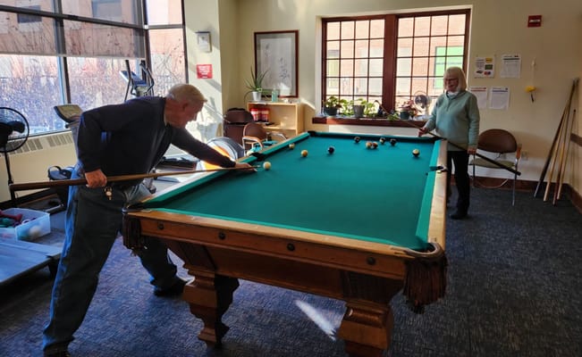 Residents playing pool in an activity room
