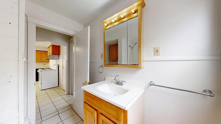 A well-lit bathroom with a sink and mirror.
