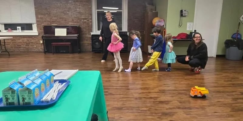 Children and staff participating in a dance class indoors