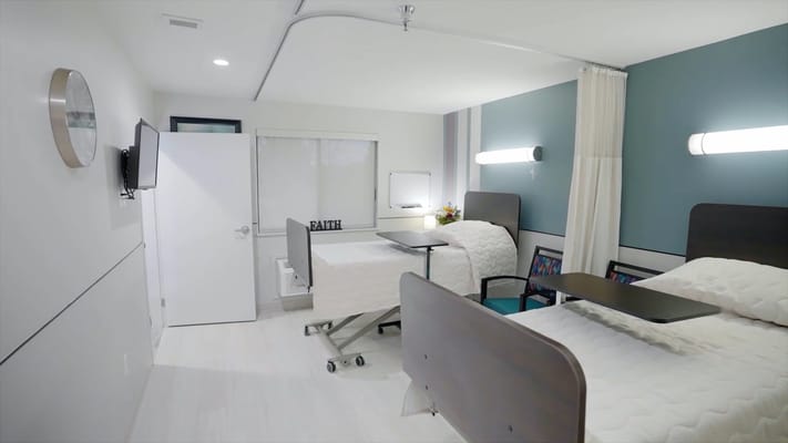 Patient room with two beds and a small table in Villa Springfield